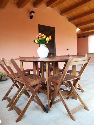 a wooden table with a vase with flowers on it at B&B Casa Ghiani in Ìsili