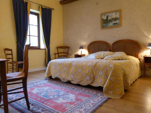 1 dormitorio con 1 cama, mesa y sillas en Moulin du Fief Gentil, en Bléré