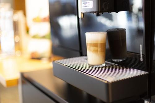 a cup of coffee sitting on top of a machine at Wilhelm-Kempf-Haus in Wiesbaden