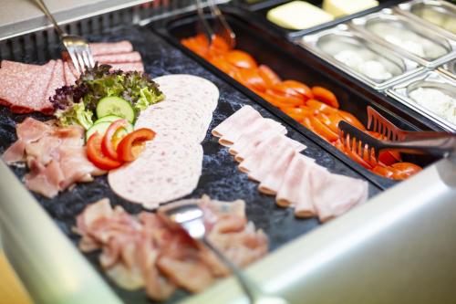 a tray of food with meats and vegetables on at Wilhelm-Kempf-Haus in Wiesbaden