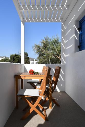 a wooden table and two chairs on a patio at 21 luxury apartments in Naousa