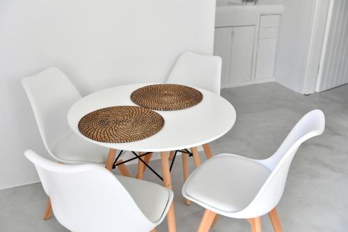 a white table with four white chairs around it at 21 luxury apartments in Naousa