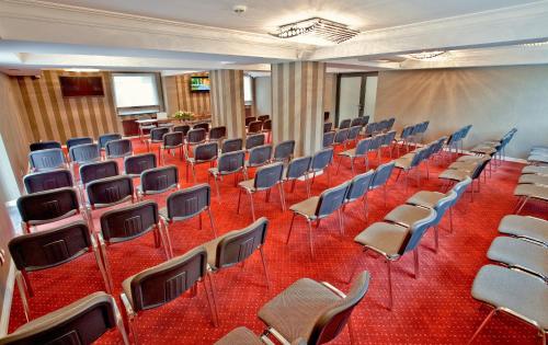 an empty lecture hall with chairs and a screen at M Hotel Sosnowiec in Sosnowiec