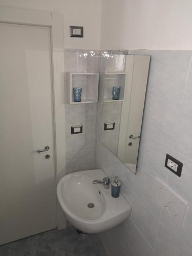 a white bathroom with a sink and a mirror at Casa Midori in Lecce