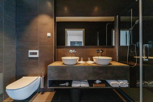 ein Bad mit 2 Waschbecken und einer Dusche in der Unterkunft WUD hotel in Ljubljana