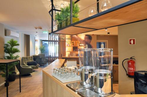 a bar with a bunch of glasses on a counter at Spot Apartments Trindade in Porto