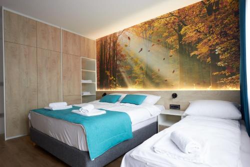 two beds in a room with a painting on the wall at Apartment Zara Sarajevo in Sarajevo