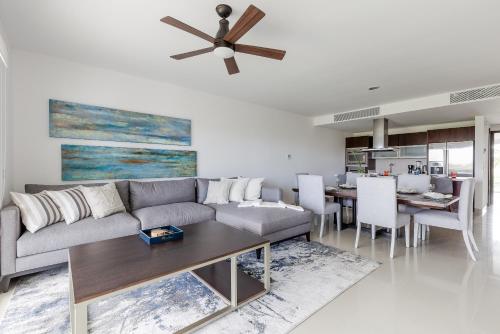 a living room with a couch and a ceiling fan at Mareazul Beach Front Condos At playa del Carmen in Playa del Carmen