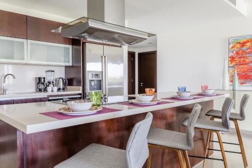 a kitchen with a counter with chairs and a sink at Mareazul Beach Front Condos At playa del Carmen in Playa del Carmen