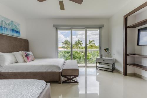 a bedroom with a bed and a tv and a window at Mareazul Beach Front Condos At playa del Carmen in Playa del Carmen