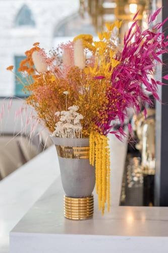 a vase filled with flowers on a table at Hôtel Cosmopolitain in Biarritz