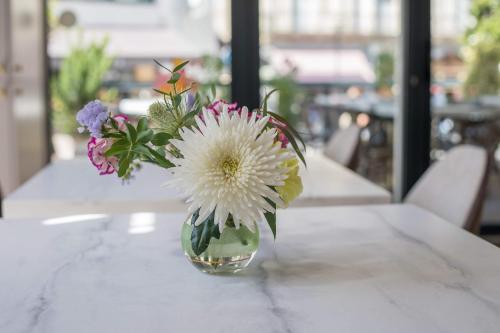 a vase filled with flowers sitting on a table at Hôtel Cosmopolitain in Biarritz