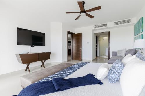 a bedroom with a large bed and a flat screen tv at Mareazul Beach Front Condos At playa del Carmen in Playa del Carmen