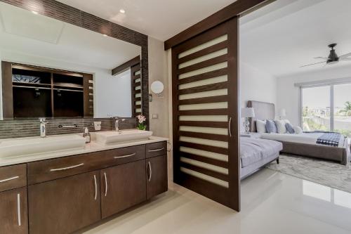a bathroom with a sink and a bed in a room at Mareazul Beach Front Condos At playa del Carmen in Playa del Carmen