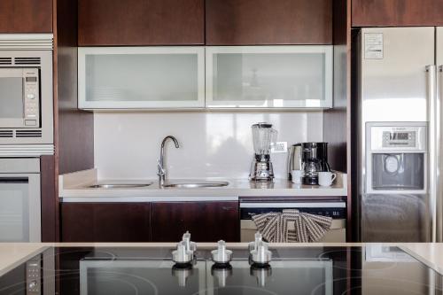 a kitchen with a sink and a counter top at Mareazul Beach Front Condos At playa del Carmen in Playa del Carmen