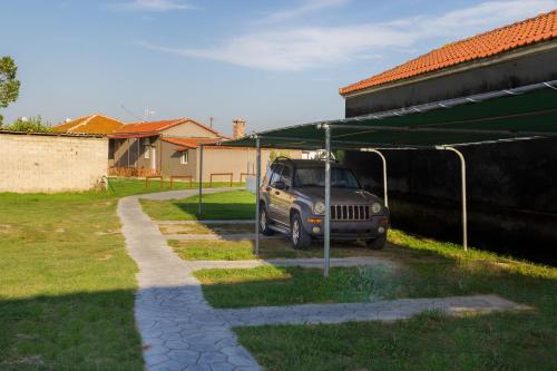 a jeep parked in a parking lot next to a building at Kremasti Rooms in Kremastí