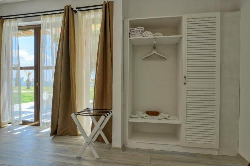 una camera con mensola, sedia e finestra di Ayvalık Sea Resort a Ayvalık