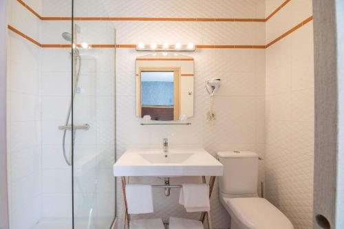 a bathroom with a sink and a toilet and a shower at Hôtel Cosmopolitain in Biarritz