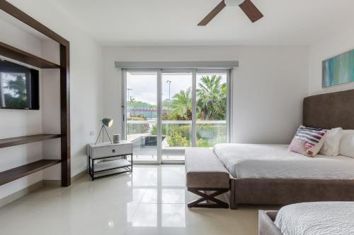 a white bedroom with two beds and a window at Mareazul Beach Front Condos At playa del Carmen in Playa del Carmen