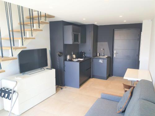 un salon avec une télévision et une cuisine dans l'établissement DUPLEX BALCON CENTRE MER 504, à Nice