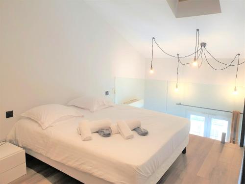 une chambre avec un grand lit blanc avec deux serviettes dans l'établissement DUPLEX CENTRE MER 505, à Nice