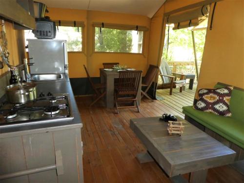 a kitchen and living room with a stove and a couch at Camping l'Avelanede in Artignosc-sur-Verdon
