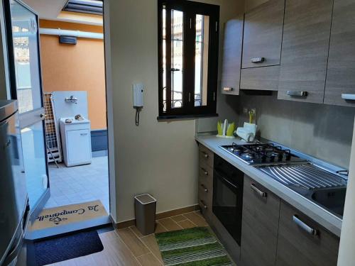 uma cozinha com um fogão e um lavatório em La CampanellaLaura em Acireale