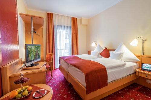 a hotel room with a bed and a television at Altkölnischer Hof in Bacharach