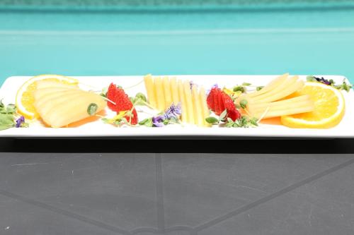 a plate of food with cheese and fruit and vegetables at FCH Hotel Expo Adults only in Guadalajara