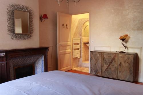 - une chambre avec un lit, une cheminée et un miroir dans l'établissement spacieux Rue d'Antibes, à Cannes