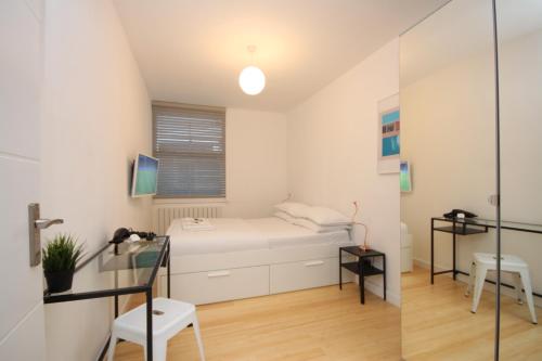 Habitación pequeña con cama y puerta de cristal en Camden Town Spacious 2 Bedroom Apartment - Sleeps 5 guests! en Londres