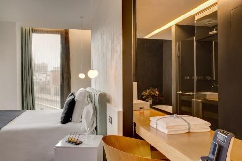 a bedroom with a bed and a desk and a bathroom at Ohla Barcelona in Barcelona