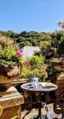 a table and chairs on a patio with flowers at Lee House in Lynton