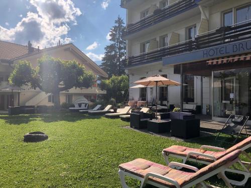 ein Hotelgebäude mit Liegestühlen und einem Sonnenschirm in der Unterkunft Guest Rooms with a great view at Residence Brunner in Wengen