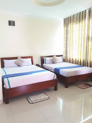 a bedroom with two beds and a window at An Phuc Hotel in Vung Tau
