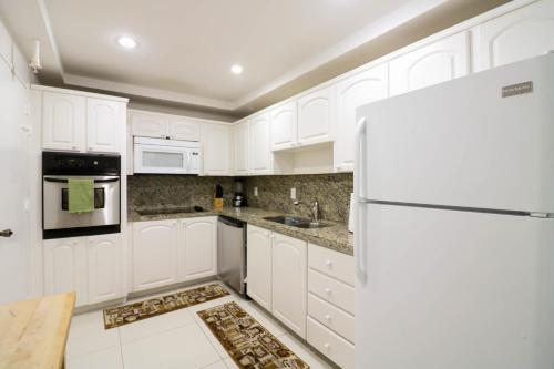 a white kitchen with white cabinets and a refrigerator at THE TIDES 2bedrooms apt 14th floor WE ARE ON THE BEACH! in Hollywood
