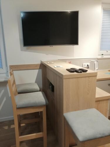 a desk with a chair and a television on a wall at Mieszkanie Świdnik in Świdnik