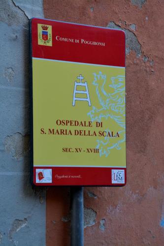 a red and yellow sign on a wall at Casa Vicolo delle Chiavi in Poggibonsi