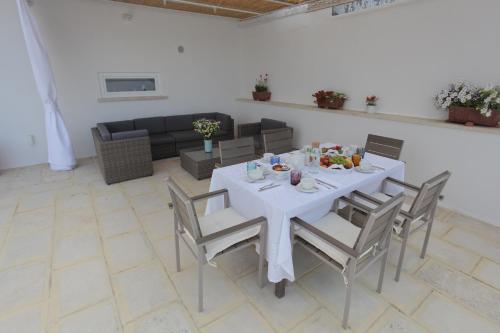 a dining room with a white table and chairs at La Bianca Terrazza in Alessano