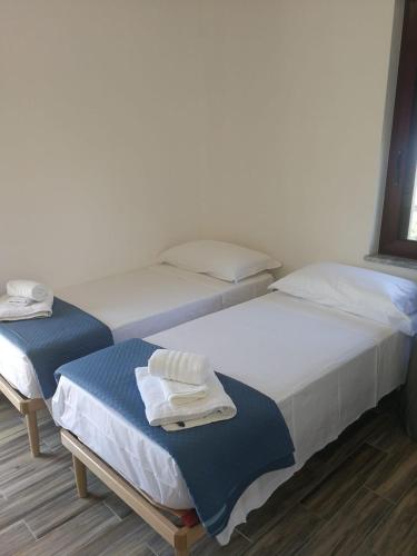 two twin beds in a room withthritisthritisthritisthritisthritisthritisthritisthritisthritis at B&B Crispino in Belvedere Marittimo