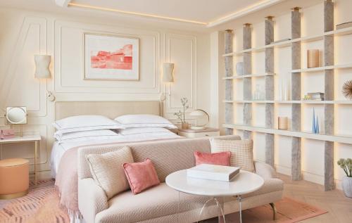 a bedroom with a bed and a couch and a table at One Aldwych in London