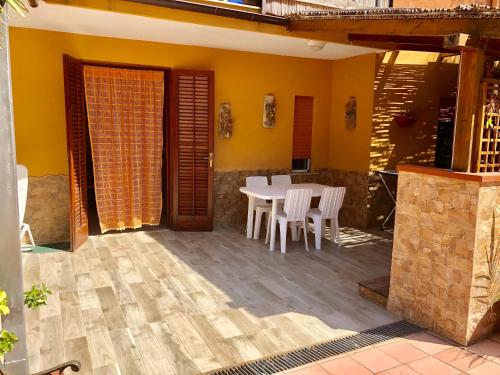 a dining room with a table and chairs on a patio at Appartamenti Cala Azzurra in Scopello