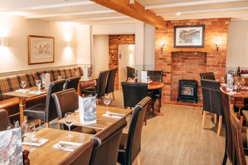 a restaurant with tables and chairs and a fireplace at The Potters Arms in Amersham