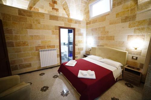 um quarto com uma cama grande e um cobertor vermelho em Il Vittoriano em Porto Cesareo