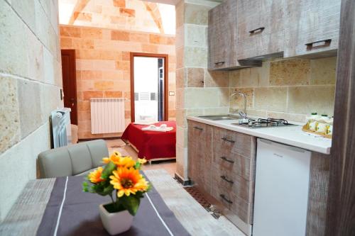 eine Küche mit einer Blumenvase auf dem Tisch in der Unterkunft Il Vittoriano in Porto Cesareo