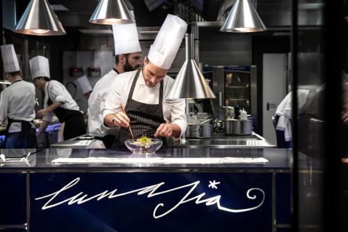 a group of chefs preparing food in a kitchen at Hotel Plaza e de Russie - Relais & Châteaux in Viareggio