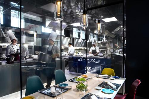 a kitchen with a table and chefs in the kitchen at Hotel Plaza e de Russie - Relais & Châteaux in Viareggio