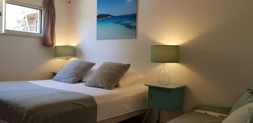 1 dormitorio con 1 cama con 2 lámparas en Chambres d'hôtes Caseddu Di Poggiale, en Figari