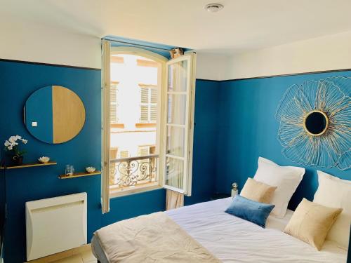 a bedroom with blue walls and a bed with a window at L'Escale au Coeur du Vieux Port de Marseille in Marseille
