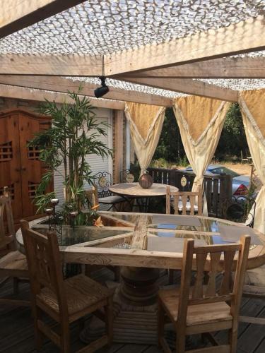 un patio avec une table et des chaises sous une pergola dans l'établissement Chalet Valle di Corti, à Pianottoli-Caldarello